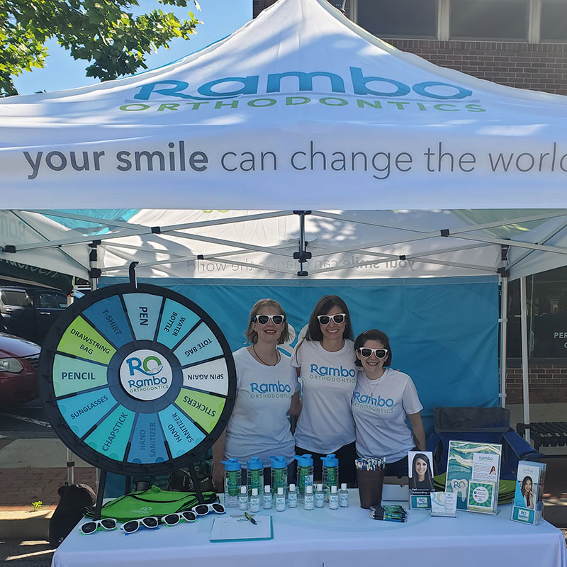A picture of Dr. Rambo and staff with their Rambo Orthodontics tent attending a community event.